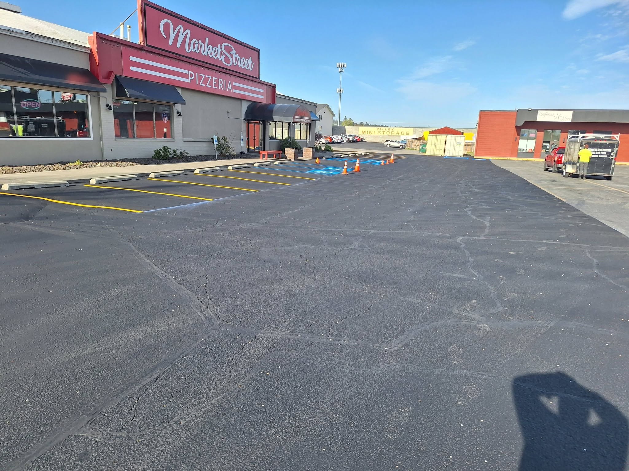 Restaurant and retail parking area with yellow lines, blue accessible spaces and parking blocks.