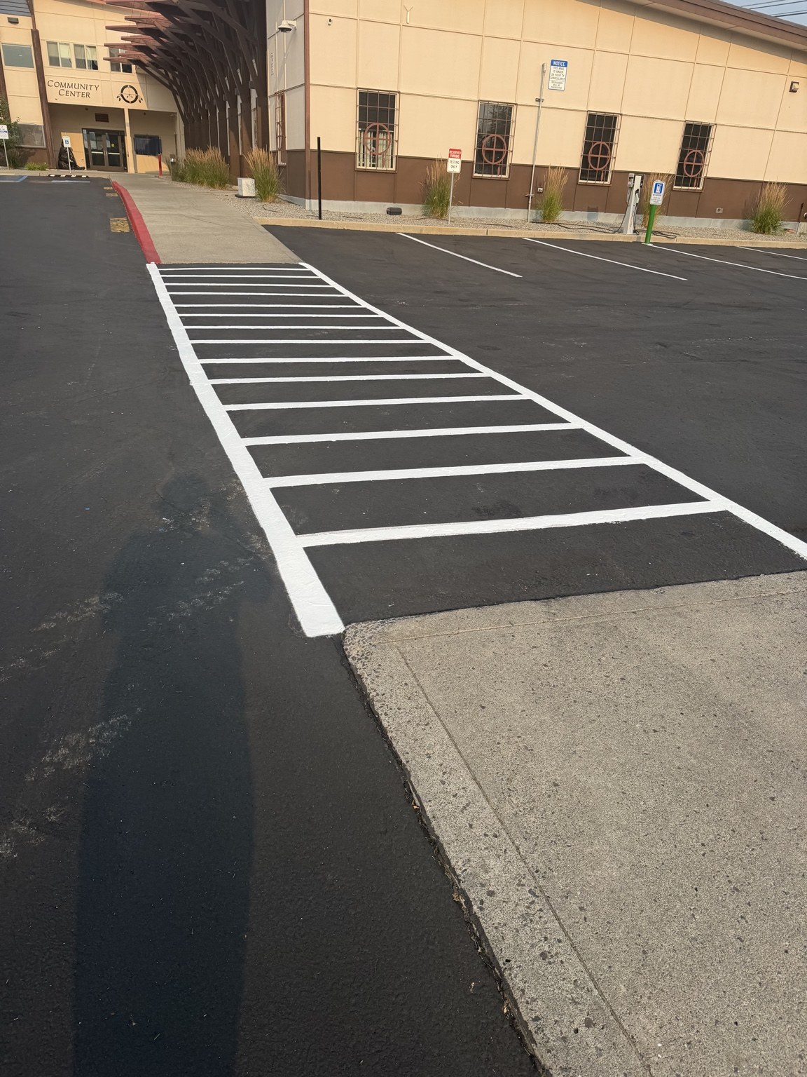 White striped access aisle and parking area beside a commercial building.